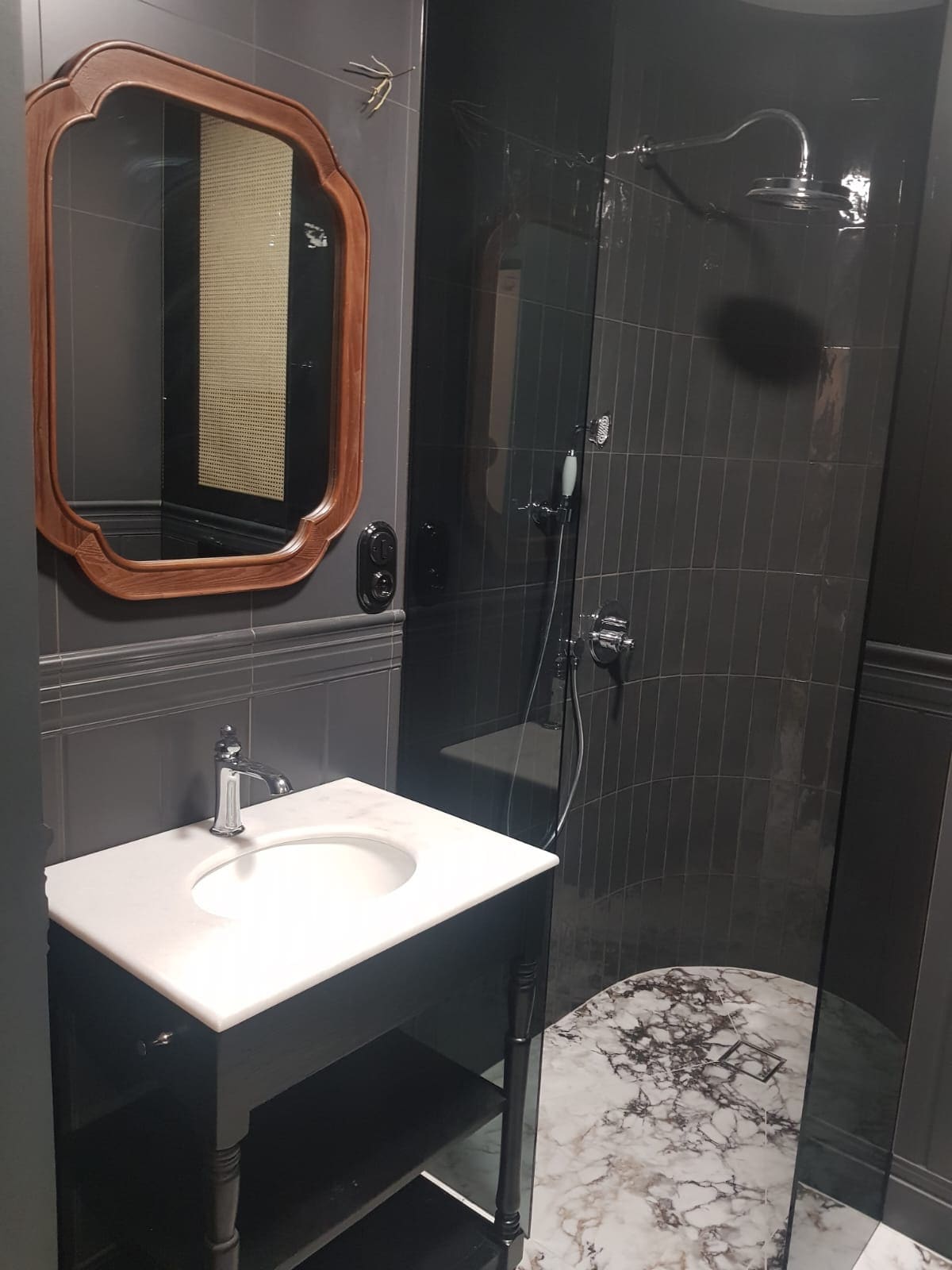 Grafitowa łazienka po remoncie we Wrocławiu – prysznic walk-in, marmurowy blat i drewniane lustro